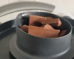 Step <p>Añade 300 gramos de agua aprovecha para añadir cascara de limón,, jengibre, menta, etc y hacer una infusión) y coloca, poco a poco, en pequeñas cantidades 100 gramos de chocolate en el cubilete. Programa 15 minutos a temperatura varoma.</p><p> </p> illustration