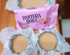 Step <p>precalentamos el horno a 200º</p><p>forramos el molde con papel vegetal mojado (es una preparación líquida)</p><p>primero vamos con la base</p><p>trituramos las galletas con un bollito de pantera rosa</p><p>y repartimos en el molde. Aplastamos con la ayuda de una cuchara</p> illustration