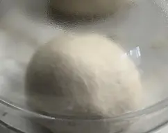 Step <p>5. Divida la masa en 4 partes y deles forma de bola. Cubra con un paño limpio y deje reposar hasta que doblen su volumen durante 10-15 minutos.</p> illustration